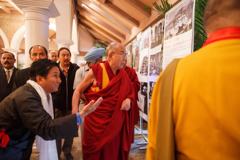 His Holiness the Dalai Lama looking at a photo exhibition on display in the meeting room for the dialogue with Russian scientists in New Delhi, India on August 7, 2017.Photo/ArtemSavateev